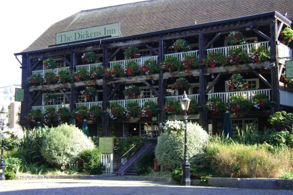 The flowers and balconies on the outside of the Dickens Inn pub