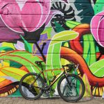 A bicycle propped against a colourful wall