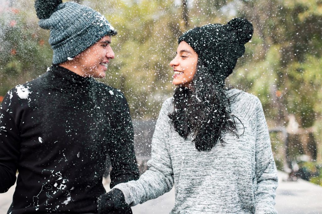 Couple enjoying winter snow in the park
