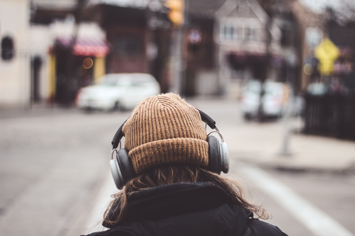 woman walking with hat and headphones